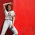 Person wearing a white t-shirt with a graphic design and text, standing against a red background
