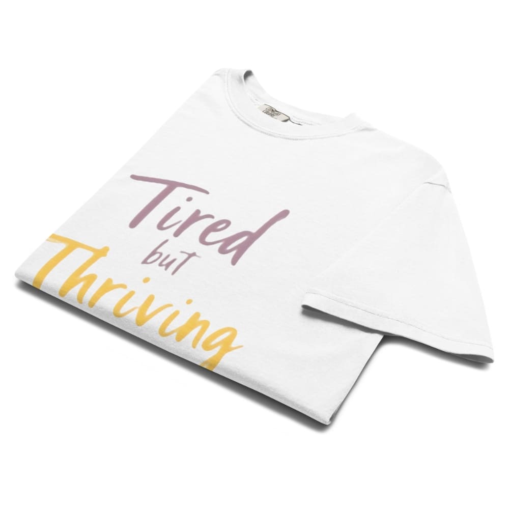 Garment-dyed relaxed fit t-shirt with motivational quote “Tired But Thriving” in modern handwritten script
