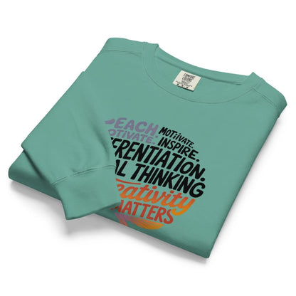 Folded teal sweatshirt with motivational text on a white background