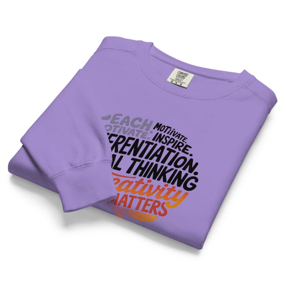 Folded purple sweatshirt with motivational text on a white background
