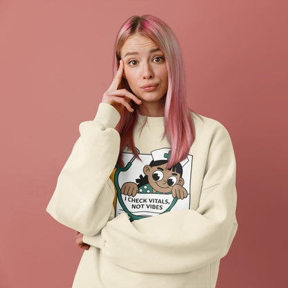 Person wearing a cream sweatshirt with a graphic design on a pink background