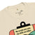 Beige t-shirt with a graphic design and text on a white background