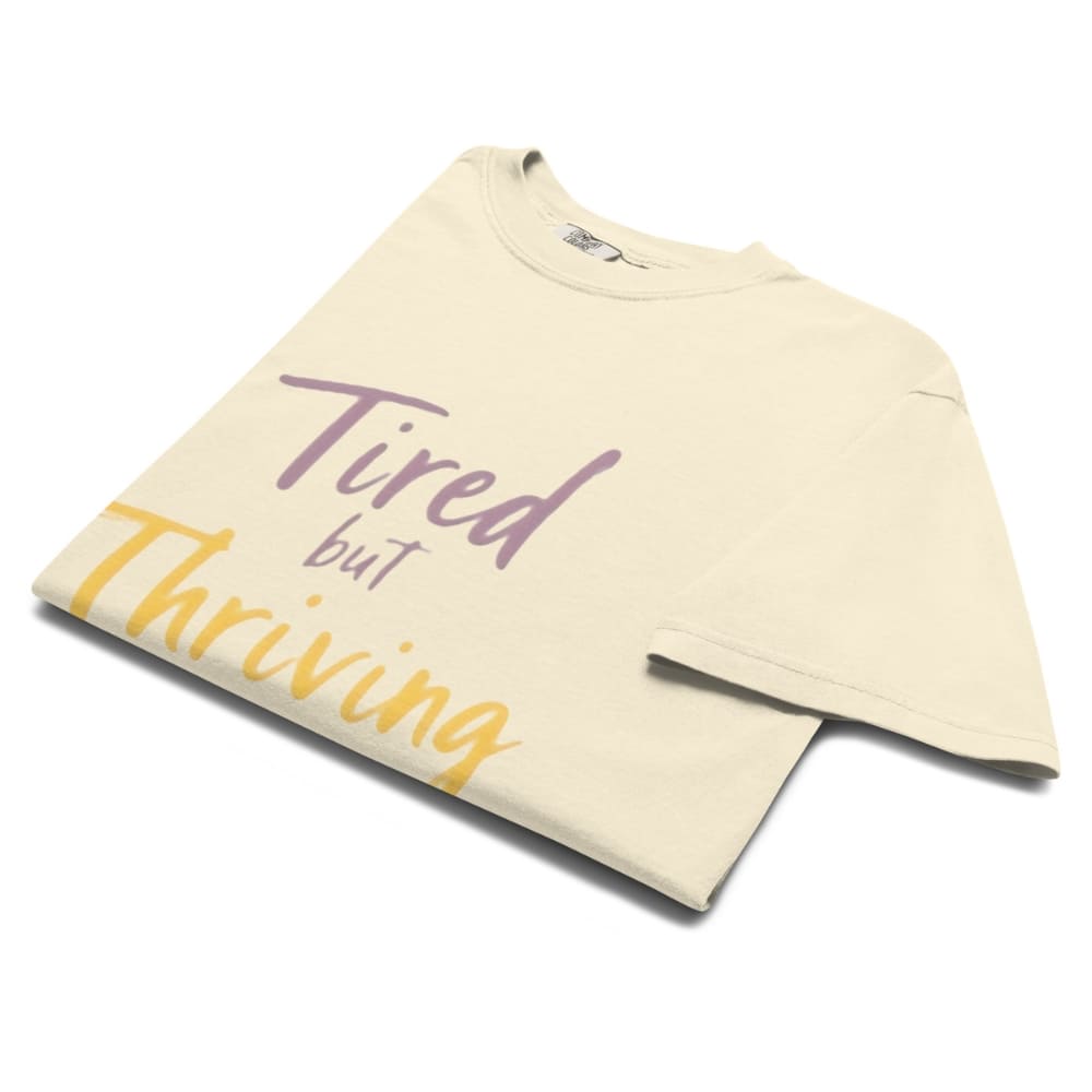 Garment-dyed relaxed fit t-shirt with motivational quote “Tired But Thriving” in modern handwritten script