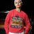 Person wearing a red sweatshirt with humorous text design.