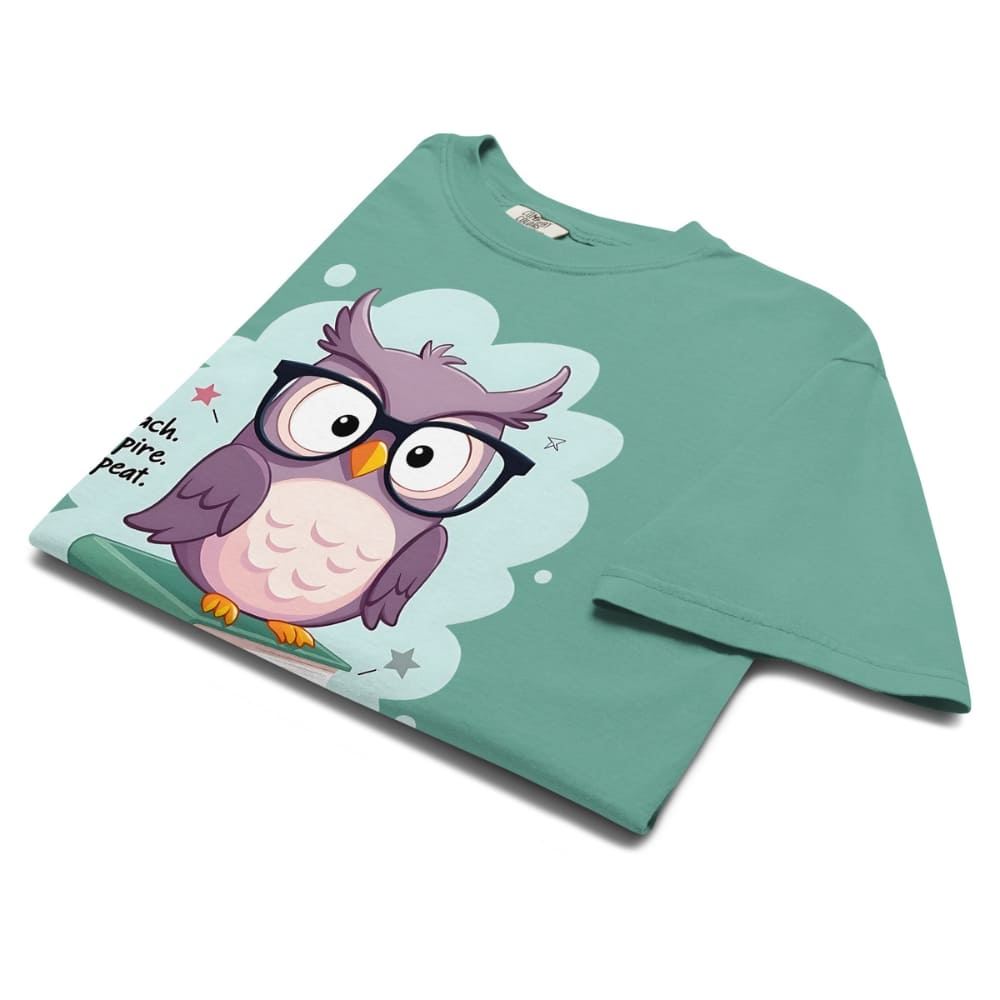 Cute purple owl with glasses sitting on stacked books, with quote "Teach. Inspire. Repeat." – printed on a teacher t-shirt