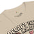 Beige t-shirt with text and graphic design on a white background
