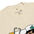 Beige t-shirt with cartoon character and stethoscope graphic, brand label visible.