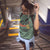 Woman wearing a green t-shirt with text at a train station