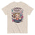 Beige t-shirt with a graphic of a woman in a laundry basket and text 'Laundry Today or Naked Tomorrow' on a white background.