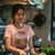 Woman wearing a pink t-shirt with a graphic design in a kitchen.