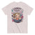 T-shirt with a graphic design of a woman in a bathtub surrounded by laundry items and text on a light pink background.