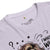 Lavender t-shirt with graphic design and text on a white background