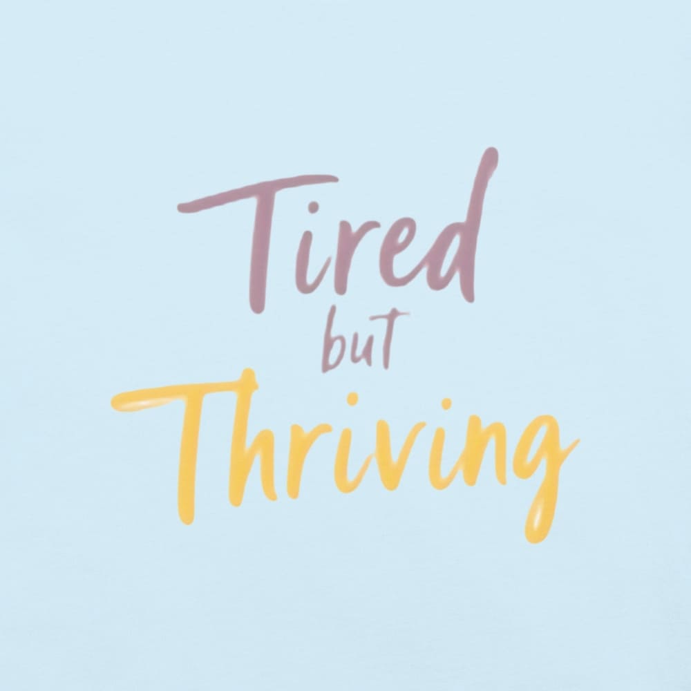 Garment-dyed relaxed fit t-shirt with motivational quote “Tired But Thriving” in modern handwritten script