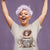 Woman wearing a t-shirt with a graphic design of a coffee cup and text, against a purple background