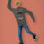 Person wearing a gray sweatshirt with a graphic design on an orange background