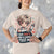 Person wearing a t-shirt with a graphic design and text.