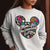 White sweatshirt with colorful graphic and text worn by a person