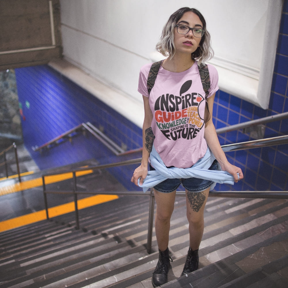 Person wearing a pink t-shirt with text and graphics, standing in an indoor setting.