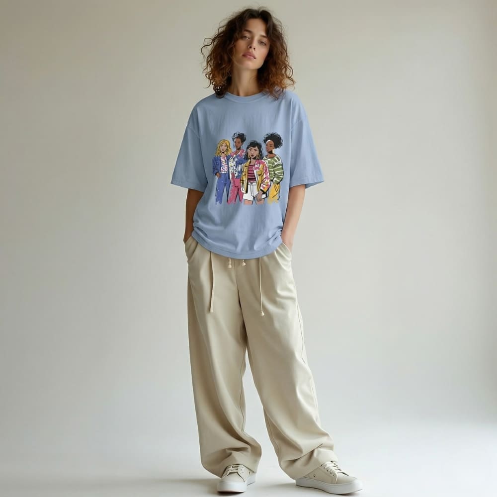 Person wearing a denim-blue t-shirt with a graphic design, beige pants, and white sneakers on a plain background