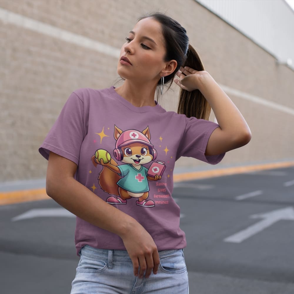Cute squirrel nurse cartoon in scrubs, pink cap, and headset holding a softball and medical kit with the phrase “Saving Lives Between Innings” — printed on a heavyweight cotton t-shirt