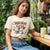 Woman wearing a t-shirt with a dog graphic and text in an outdoor setting