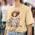 Person wearing a yellow t-shirt with a graphic of a person holding a coffee cup and text 'Don't ask me me anything before a cup of 2'.