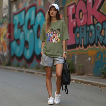 Woman wearing a green graphic t-shirt and white sneakers walking past a graffiti-covered wall.