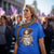 Woman wearing a blue t-shirt with a graphic design in a crowd.