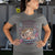 Person wearing a gray t-shirt with a graphic design and text.