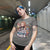 Person wearing a t-shirt with a graphic design and text in an indoor setting