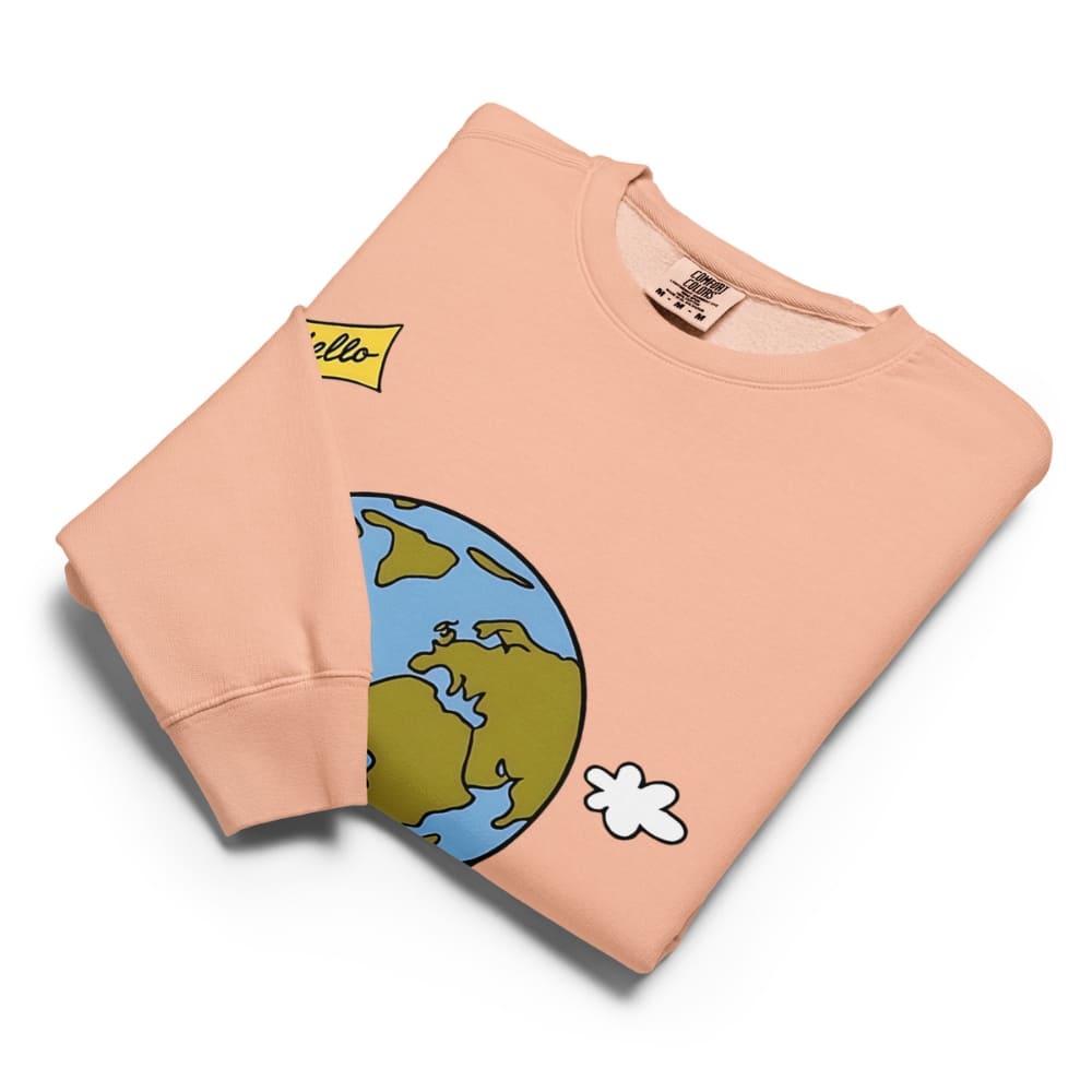 Folded peach-colored sweatshirt with a cartoon Earth design on a white background