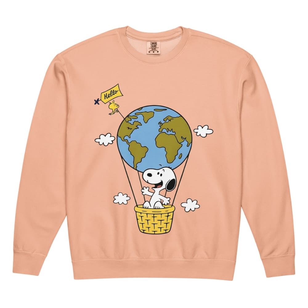 Peach-colored sweatshirt with a cartoon design of a dog in a hot air balloon with the Earth, on a peach background.
