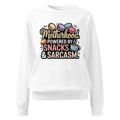 Sweatshirt design with text “Motherhood. Powered by Snacks & Sarcasm.” featuring colorful macarons and a steaming coffee cup on vintage-washed cotton fleece.