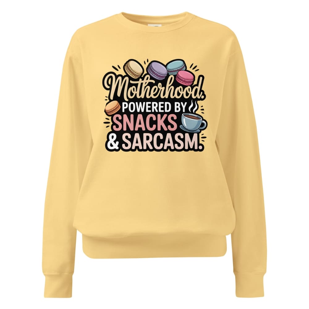 Sweatshirt design with text “Motherhood. Powered by Snacks & Sarcasm.” featuring colorful macarons and a steaming coffee cup on vintage-washed cotton fleece.