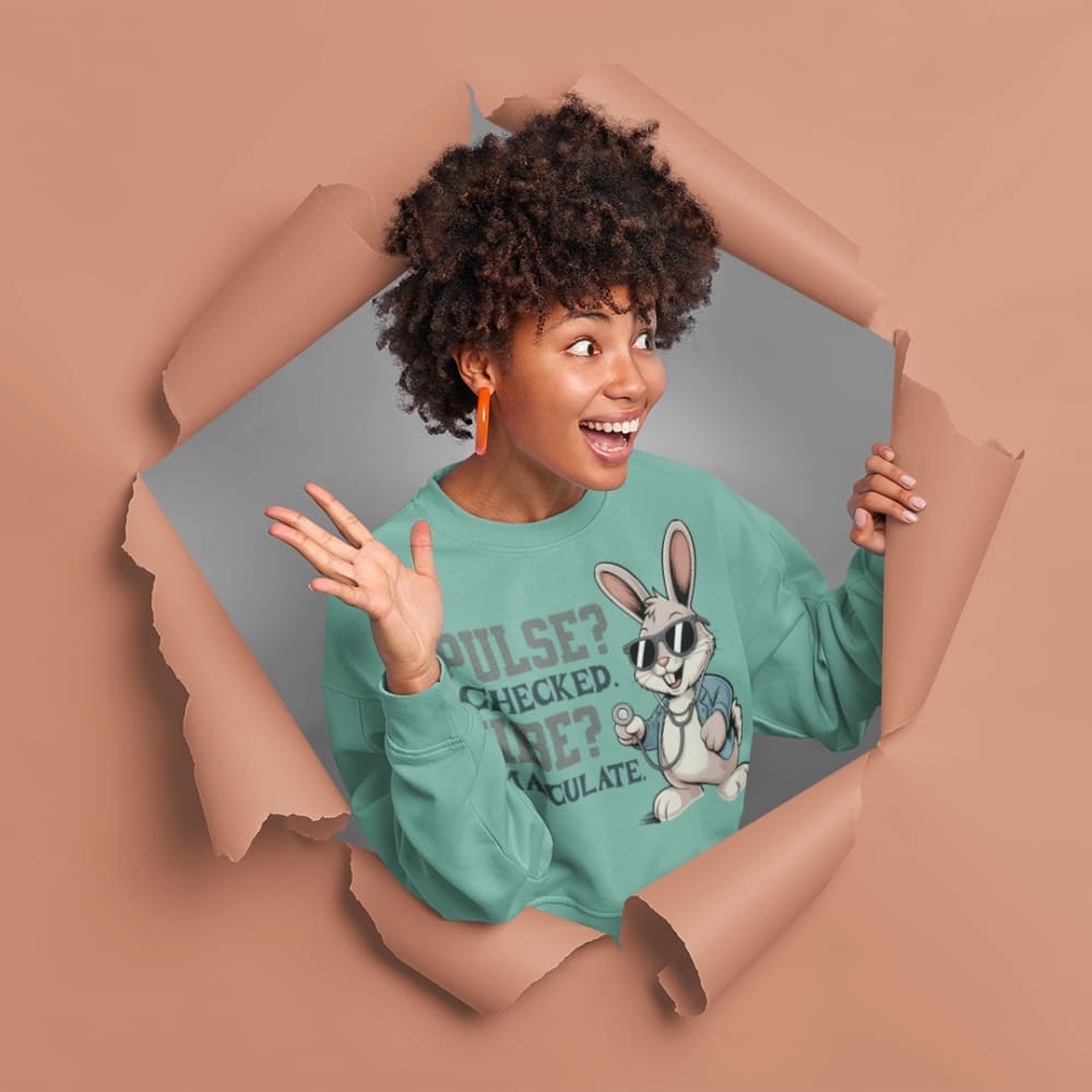 Person wearing a green sweatshirt with a cartoon character, standing behind a torn brown paper background.