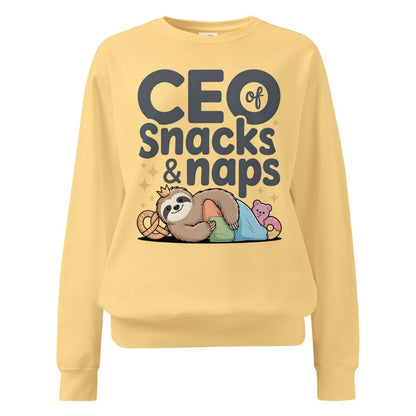 "CEO of Snacks & Naps" printed sweatshirt featuring a sloth in a crown surrounded by pretzels and plushies on vintage-washed cotton fleece