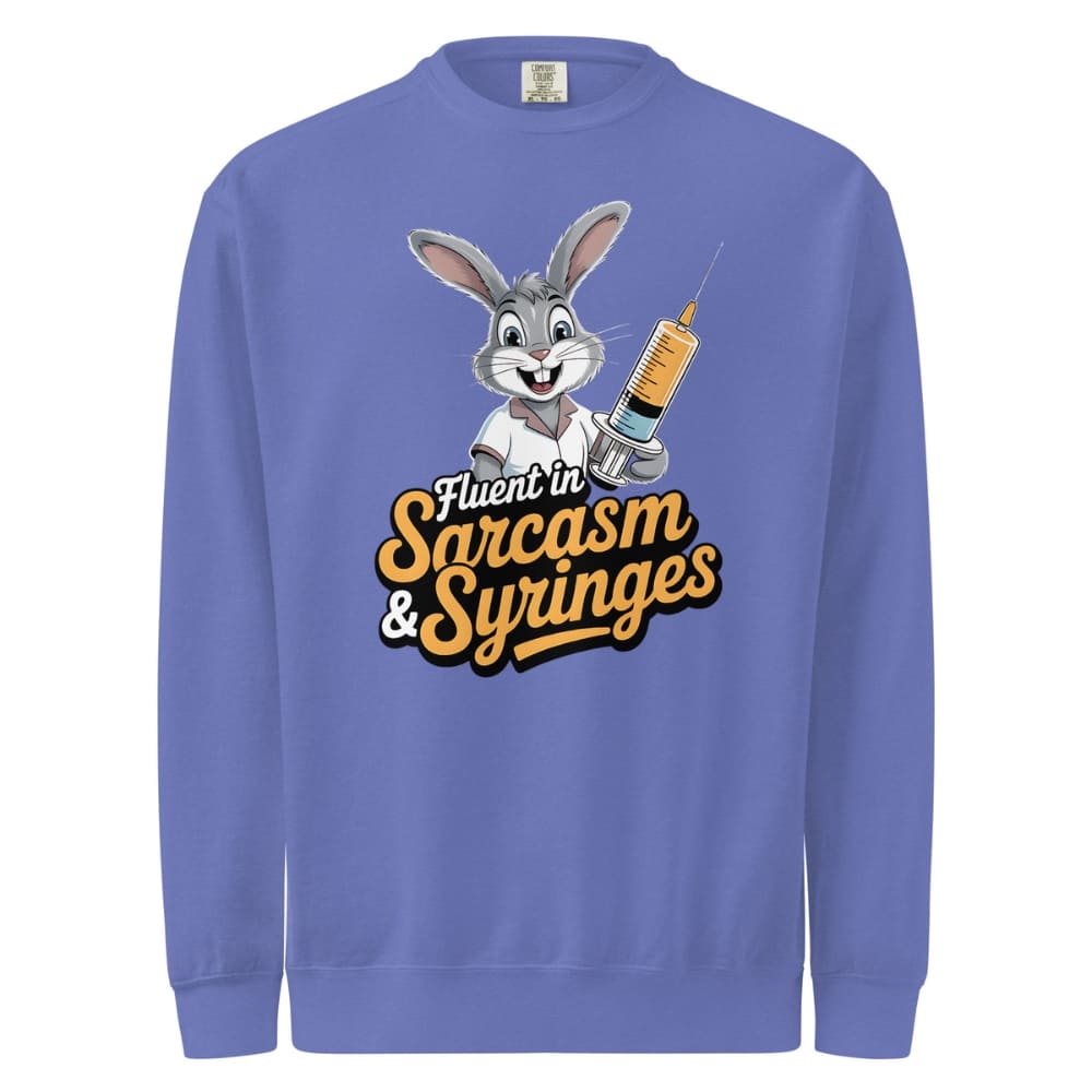 Blue sweatshirt with cartoon character holding a syringe and text 'Fluent in Sarcasm & Syringes' on a white background