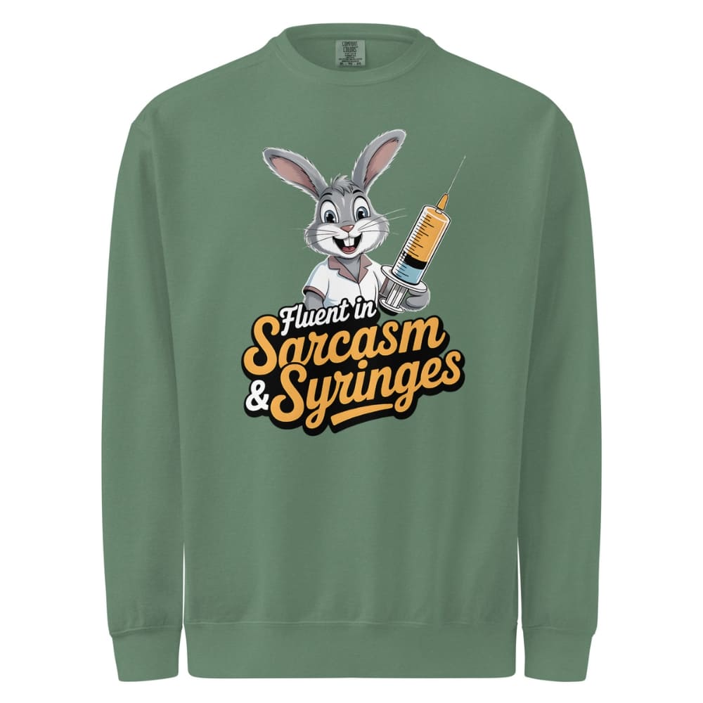 Green sweatshirt with cartoon character holding a syringe and text 'Fluent in Sarcasm & Syringes' on a white background