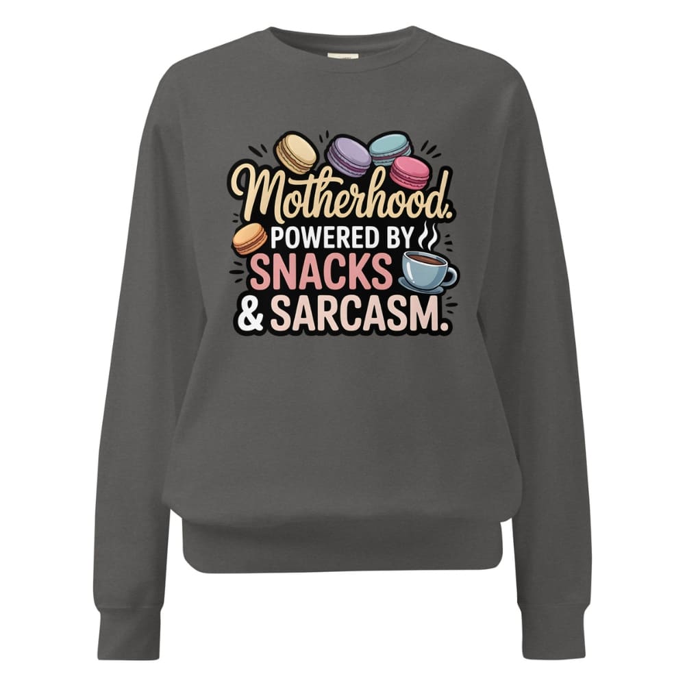 Sweatshirt design with text “Motherhood. Powered by Snacks & Sarcasm.” featuring colorful macarons and a steaming coffee cup on vintage-washed cotton fleece.