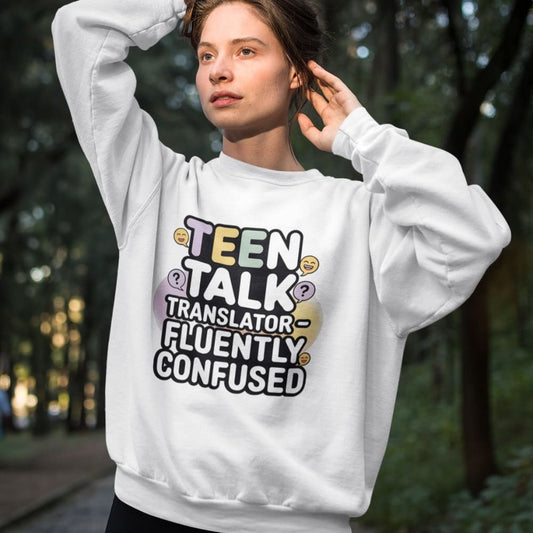 Person wearing a white sweatshirt with 'Teen Talk Translator Fluently Confused' text in an outdoor setting.