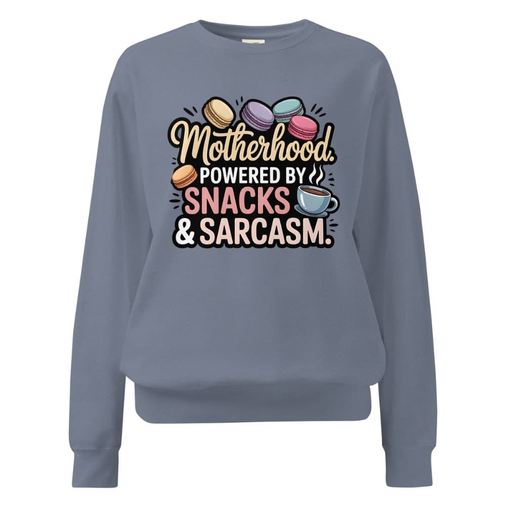 Sweatshirt design with text “Motherhood. Powered by Snacks & Sarcasm.” featuring colorful macarons and a steaming coffee cup on vintage-washed cotton fleece.