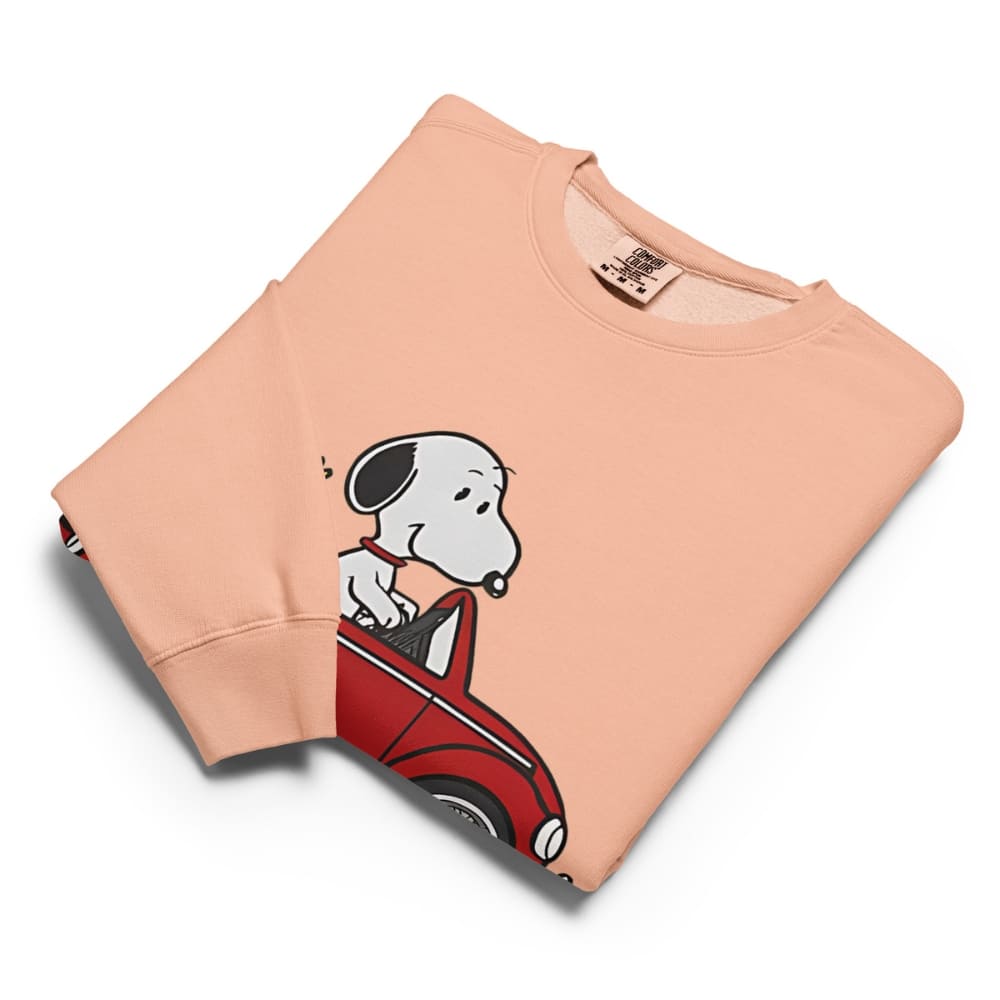 Folded peach-colored sweatshirt with a cartoon dog design on a white background