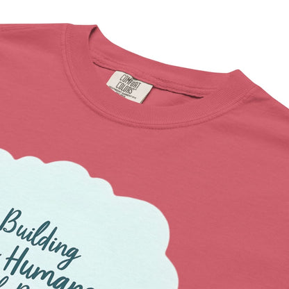 Illustrated t-shirt design with the quote "Building Tiny Humans with Big Dreams" surrounded by a family parenting scene