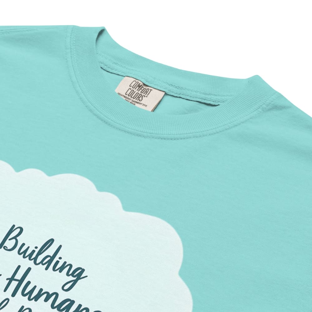 Illustrated t-shirt design with the quote "Building Tiny Humans with Big Dreams" surrounded by a family parenting scene