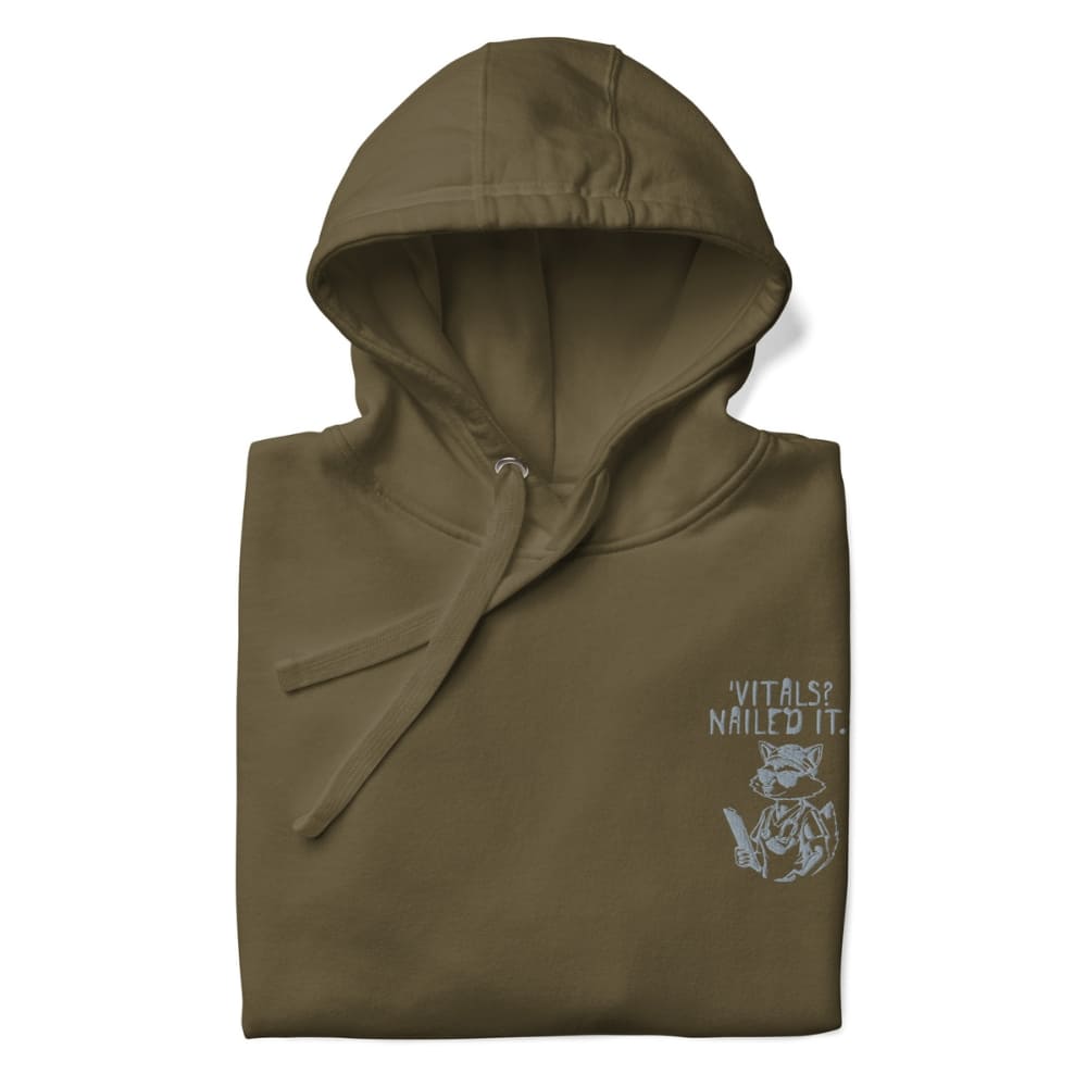 Raccoon nurse graphic wearing scrubs and sunglasses holding a clipboard under the quote “Vitals? Nailed It.” – printed on a black Cotton Heritage hoodie