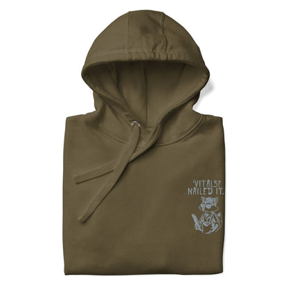 Raccoon nurse graphic wearing scrubs and sunglasses holding a clipboard under the quote “Vitals? Nailed It.” – printed on a black Cotton Heritage hoodie