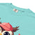 Cute cartoon owl cheerleader holding a pom-pom and clipboard, wearing a red cap with the quote “Behind Every Great Swing Is a Loud Mom” – featured on garment-dyed heavyweight cotton tee