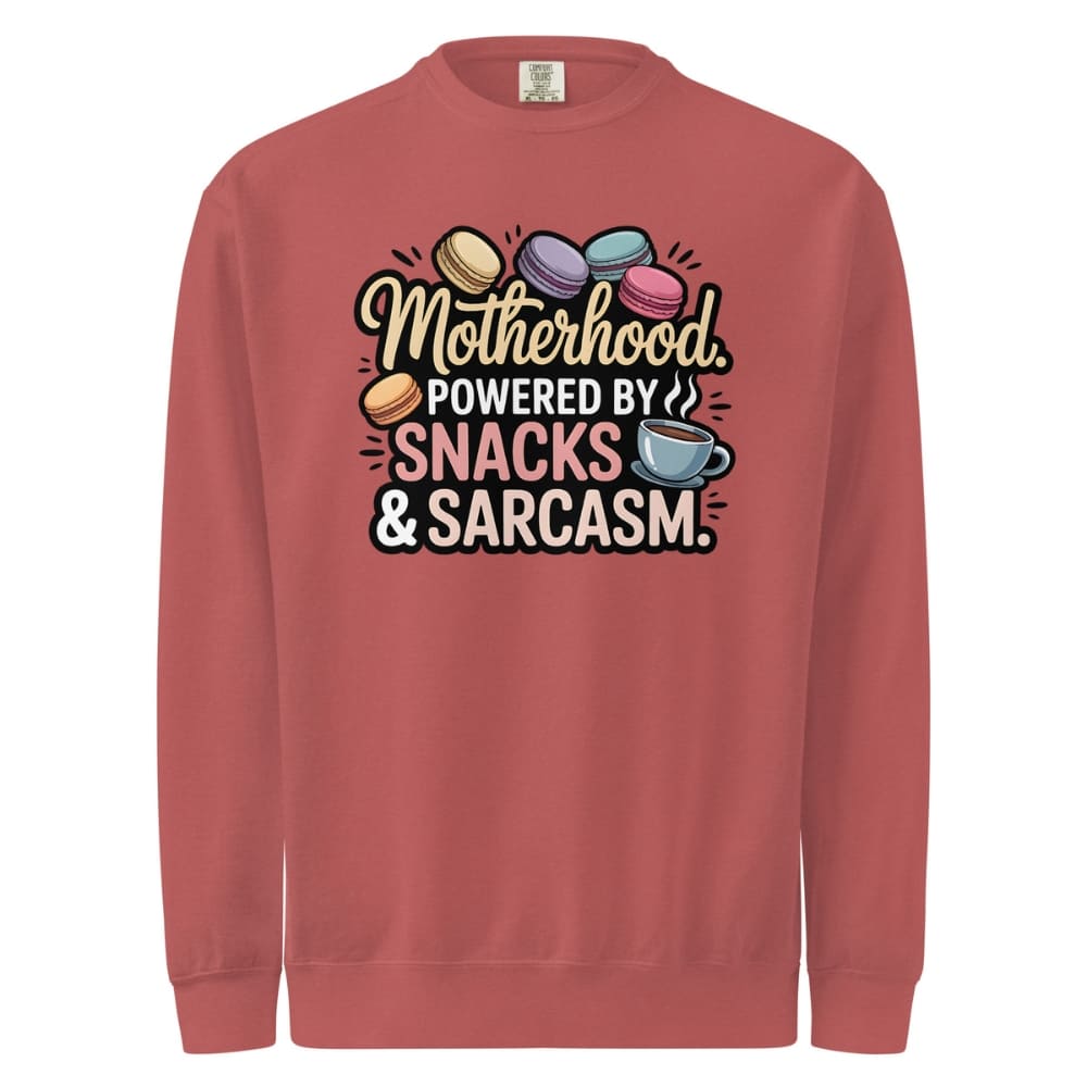 Sweatshirt design with text “Motherhood. Powered by Snacks & Sarcasm.” featuring colorful macarons and a steaming coffee cup on vintage-washed cotton fleece.