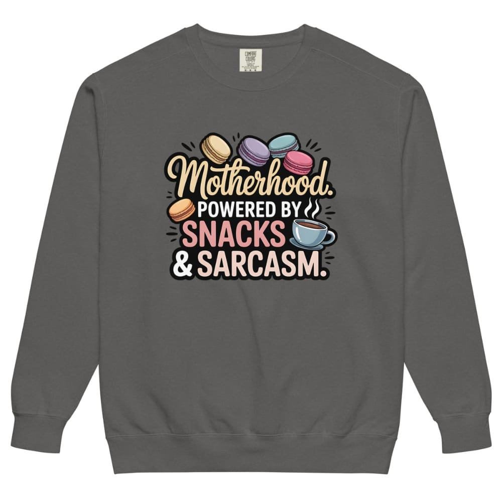 Sweatshirt design with text “Motherhood. Powered by Snacks & Sarcasm.” featuring colorful macarons and a steaming coffee cup on vintage-washed cotton fleece.