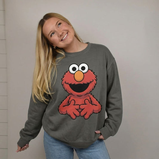 Person wearing a gray sweatshirt with a red character design on a plain background